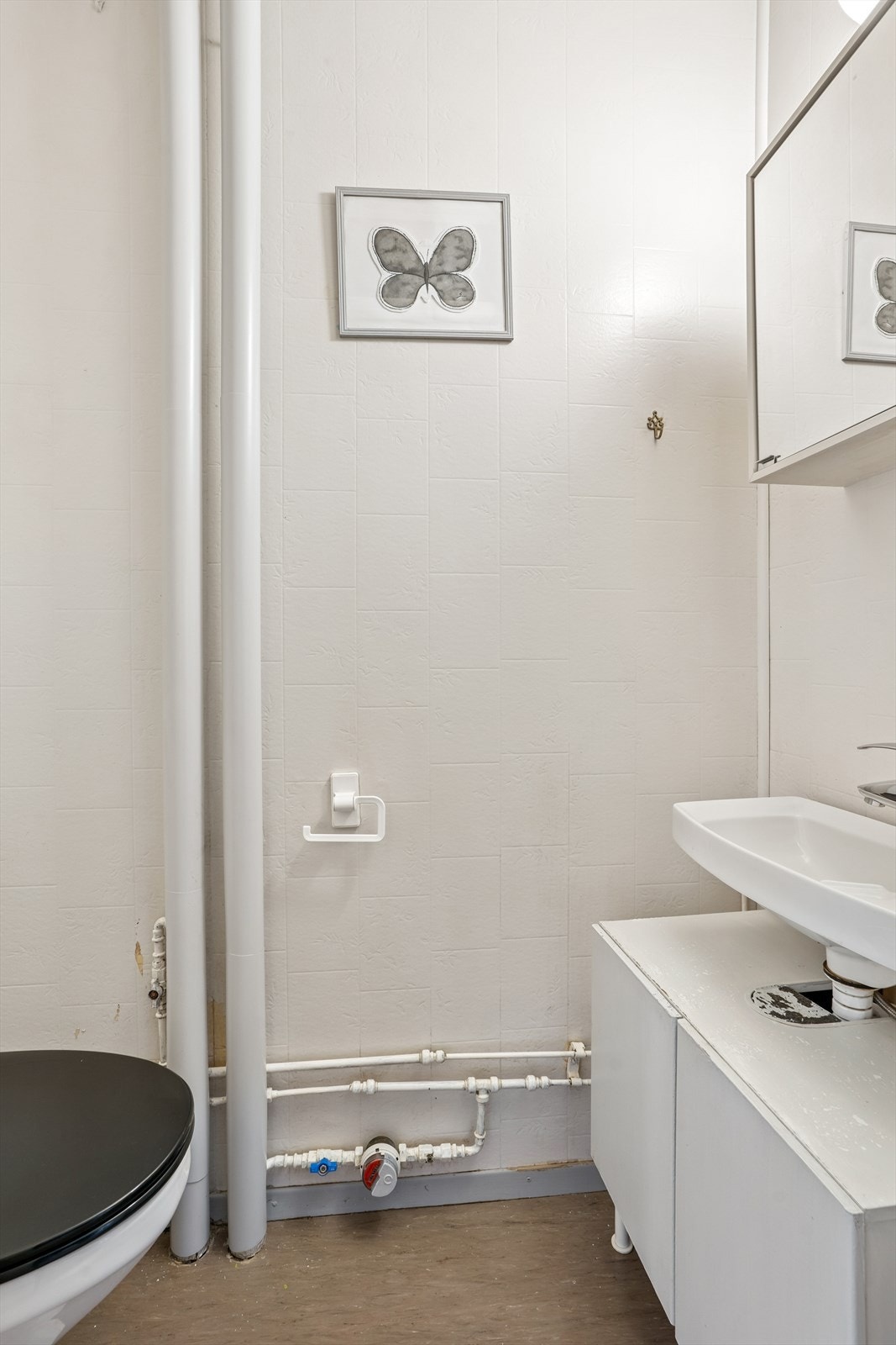 Ved inngangen har vi et toalettrom innredet med vegghengt servant med ett-greps blandebatteri, underskap, speilskap og gulvstående toalett. Galleribilde