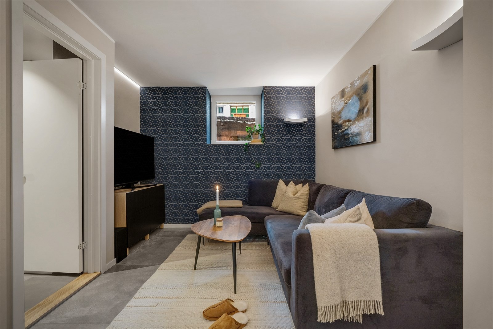 Alle flater er malt i behagelige delikate farger, det er benyttet tapet på den ene stueveggen. Gulvet er utført med lekre fliser og lunt teppegulv. Galleribilde