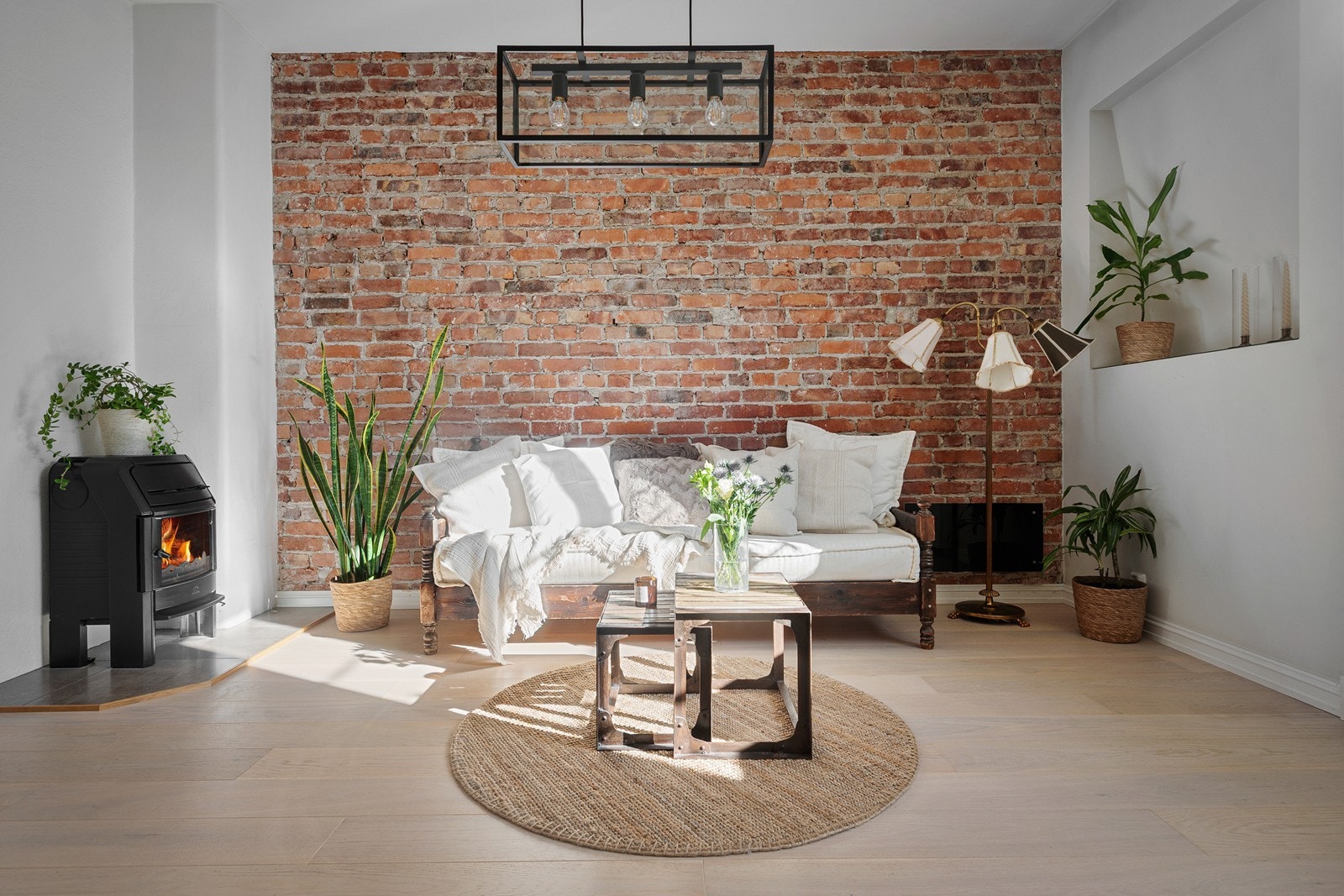 Teglsteinsveggen kombinert med lyse vegger gir en lun og rustikk atmosfære Galleribilde