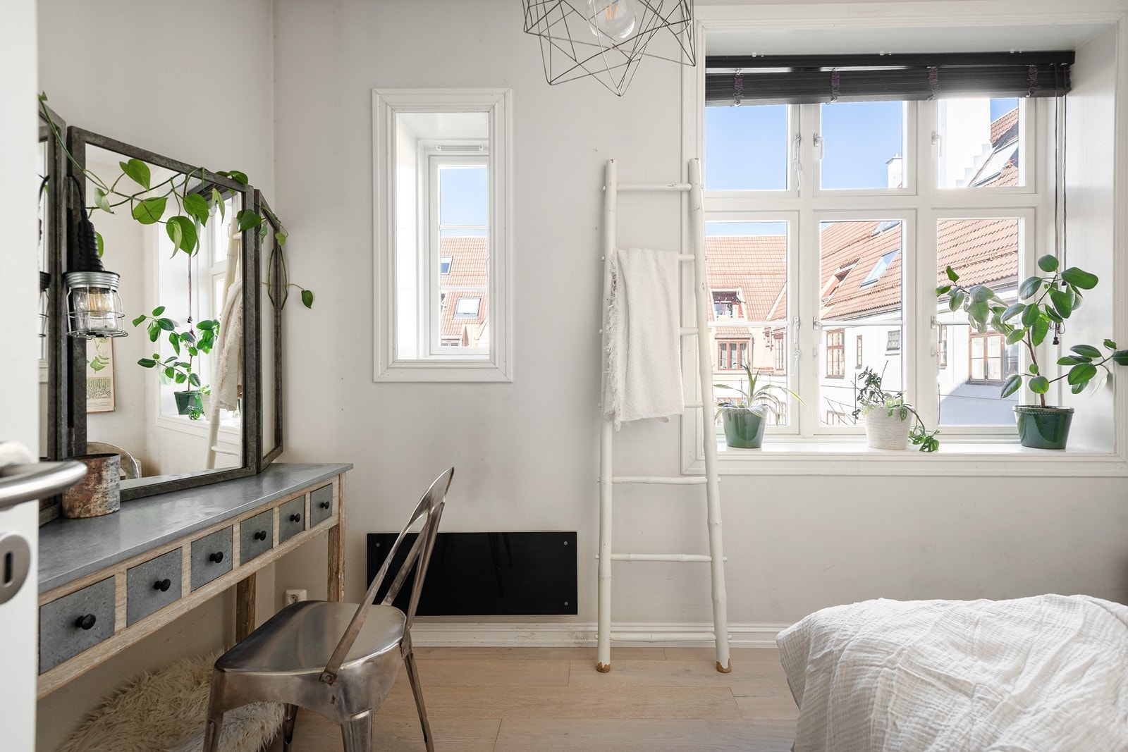 Lekkert soverom med store vinduer og panelovn for oppvarming Galleribilde