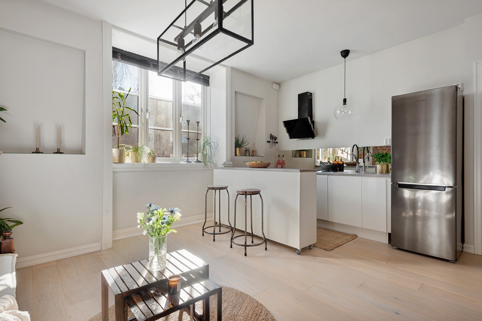 Lyst kjøkken med integrerte hvitevarer og praktisk kjøkkenøy med hjul Galleribilde