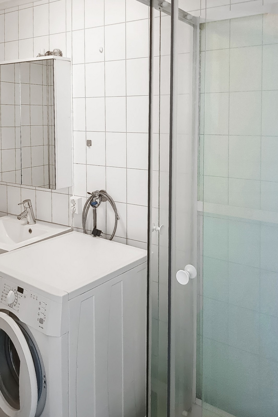 Bad med gulv- og veggfliser, speilskap, dusjkabinett og varme i gulvet. Plass til vaskemaskin. Galleribilde