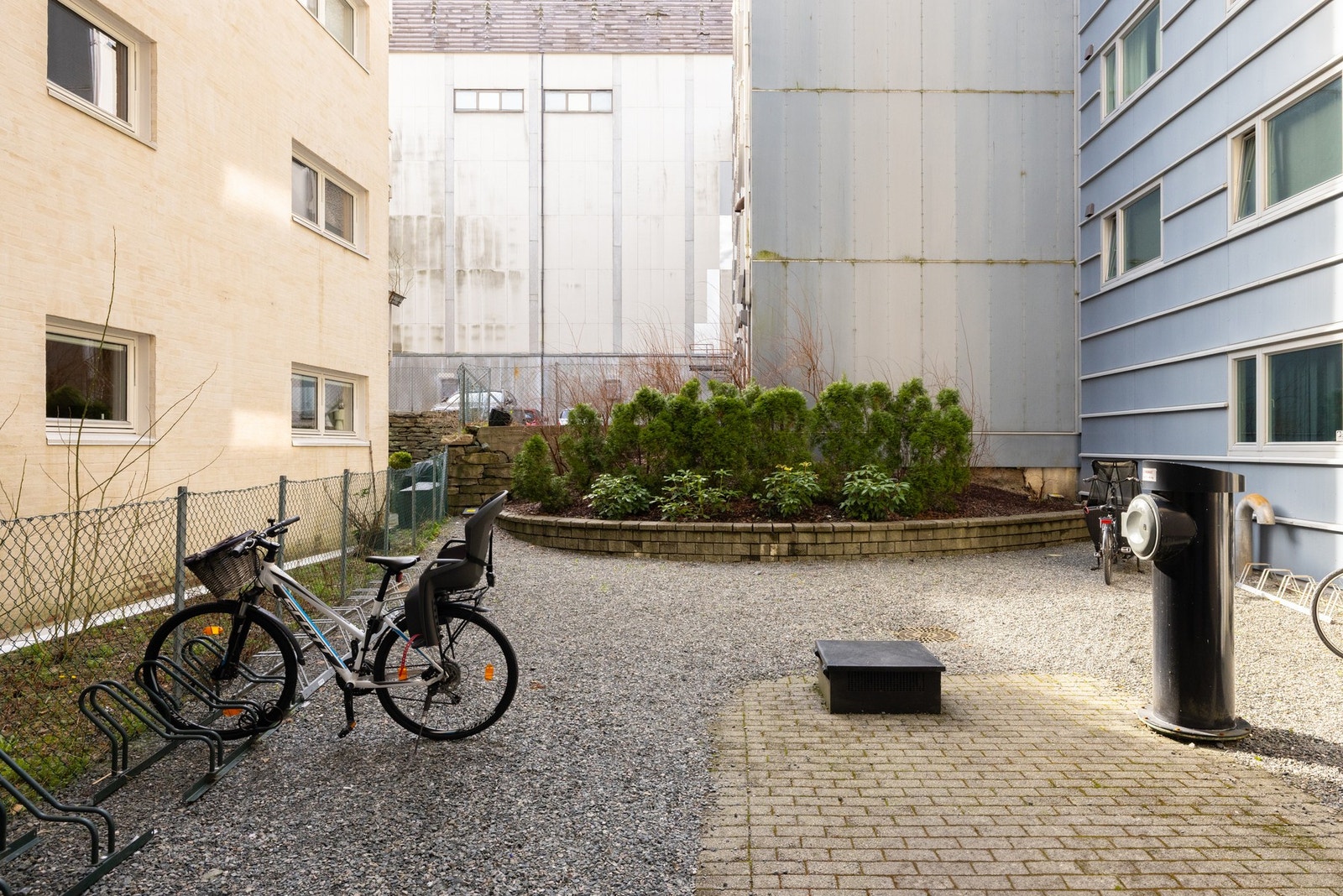 Inngangsparti med fellesområde i bakgården. Inngangspartiet er lukket mot hovedgaten. Galleribilde