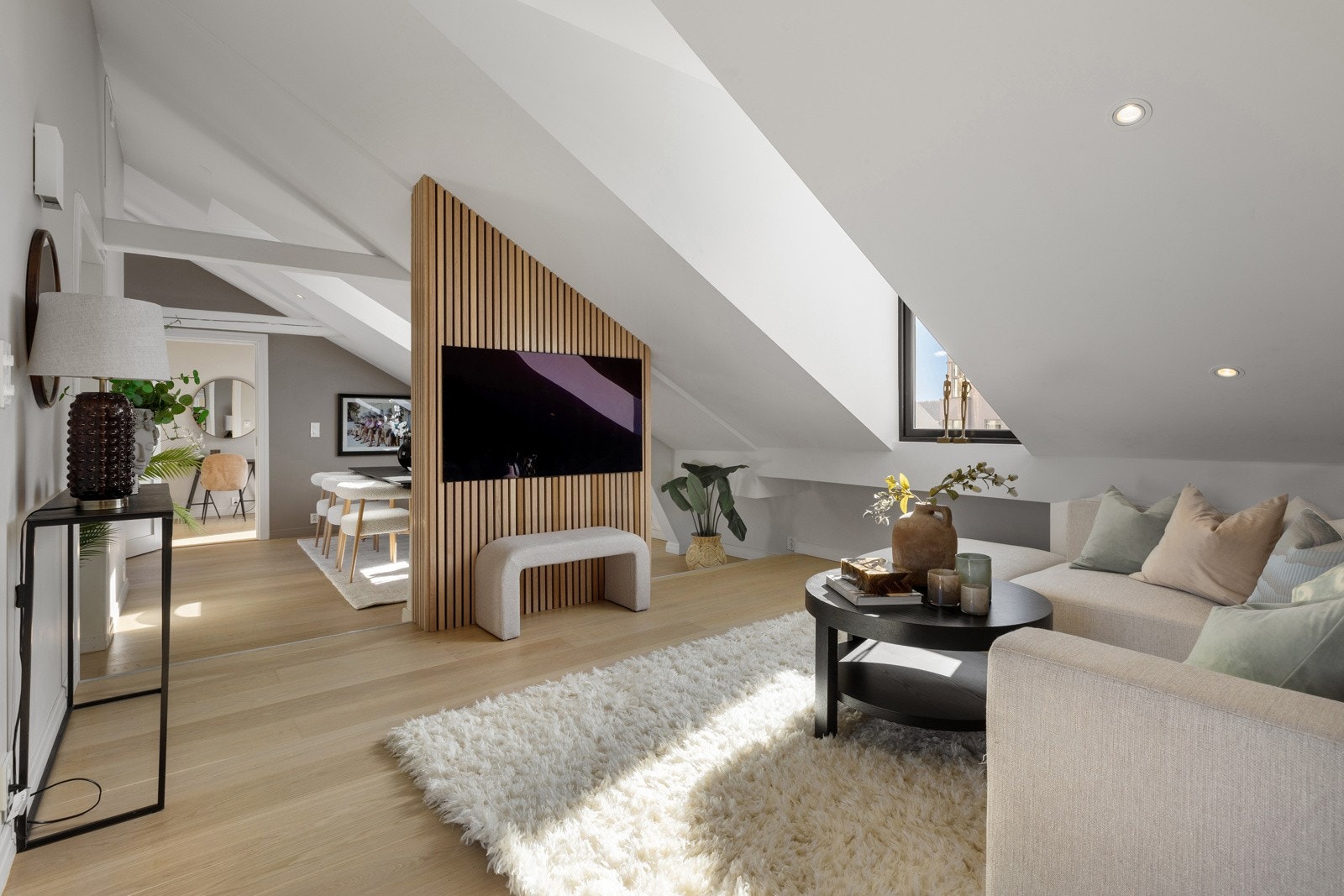 TV-veggen med spiler i stuen har bygd inn alt av tv-bokser og internett slik at dette blir skjult og gir et stilrent uttrykk Galleribilde