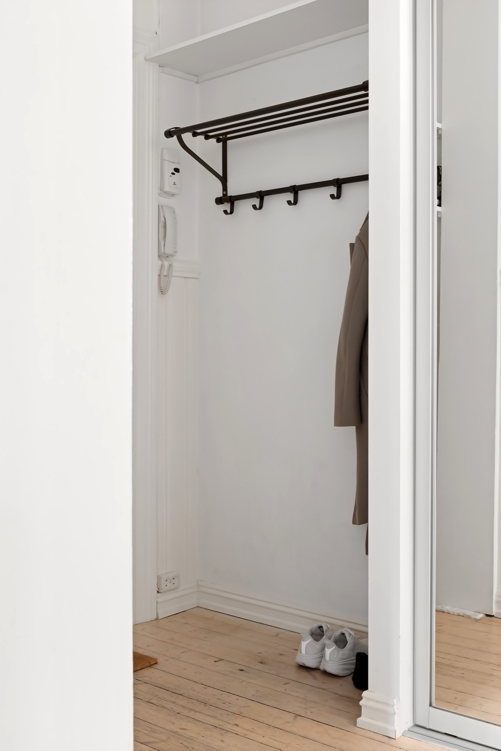 I den ene veggen er det innfelt en skyvedørsgarderobe med speilfronter, og ved siden av ytterdøren er det en nisje med hyller, knagger og dørtelefon. Ytterligere lagringsplass i to boder. Galleribilde