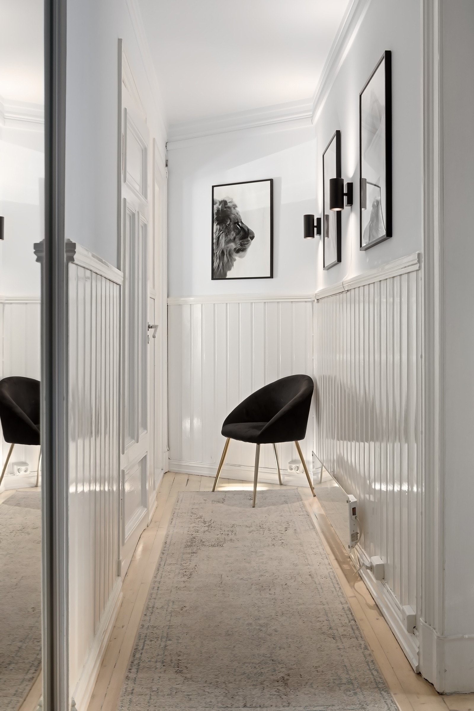 Hallen er lys og innbydende med hvitmalt brystningspanel. Galleribilde
