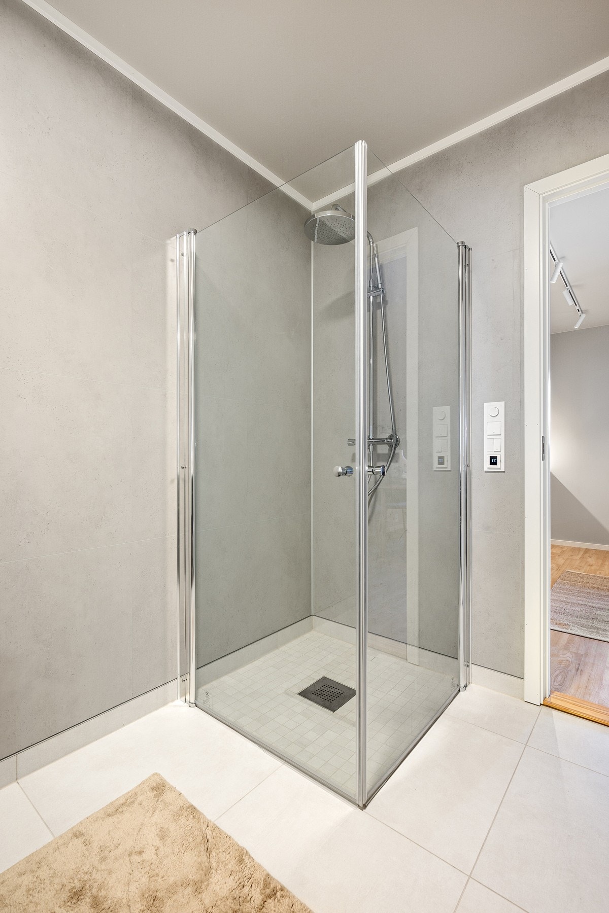 Dusjhjørne med mosaikkfliser, og innfellbare glassdører som tar liten plass Galleribilde