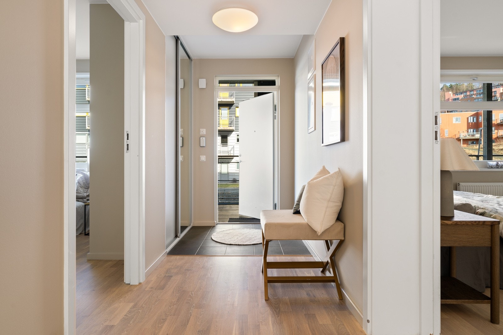 Fra parkeringskjelleren kommer du tørrskodd inn til leiligheten via en takoverbygd svalgang. Innenfor døra blir du møtt av en innbydende entré med god plass til oppbevaring i en romslig skyvedørsgarderobe. Galleribilde