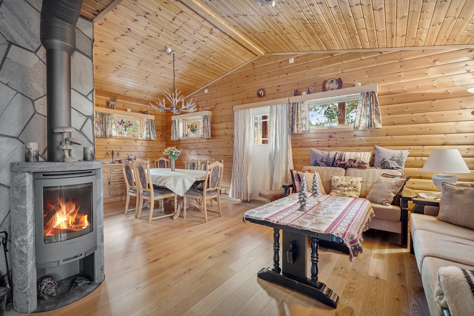 I stuen, mot kjøkkenet har man vedovn og utgang til terrasse Galleribilde