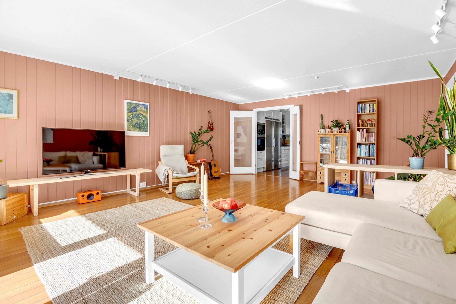 Boligens stue har god tilgang til naturlig lys gjennom store vinduer Galleribilde