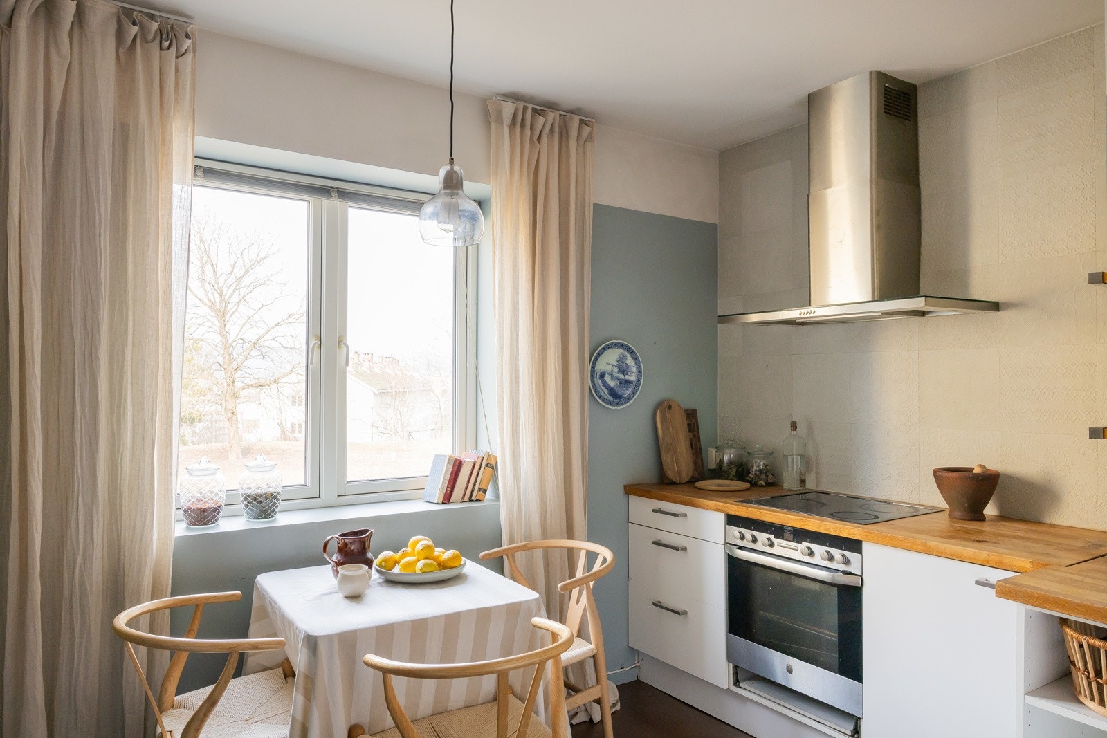 Separat kjøkken med plass til spisebord ved vindu med utsyn mot grønne og usjenerte fellesarealer. Galleribilde