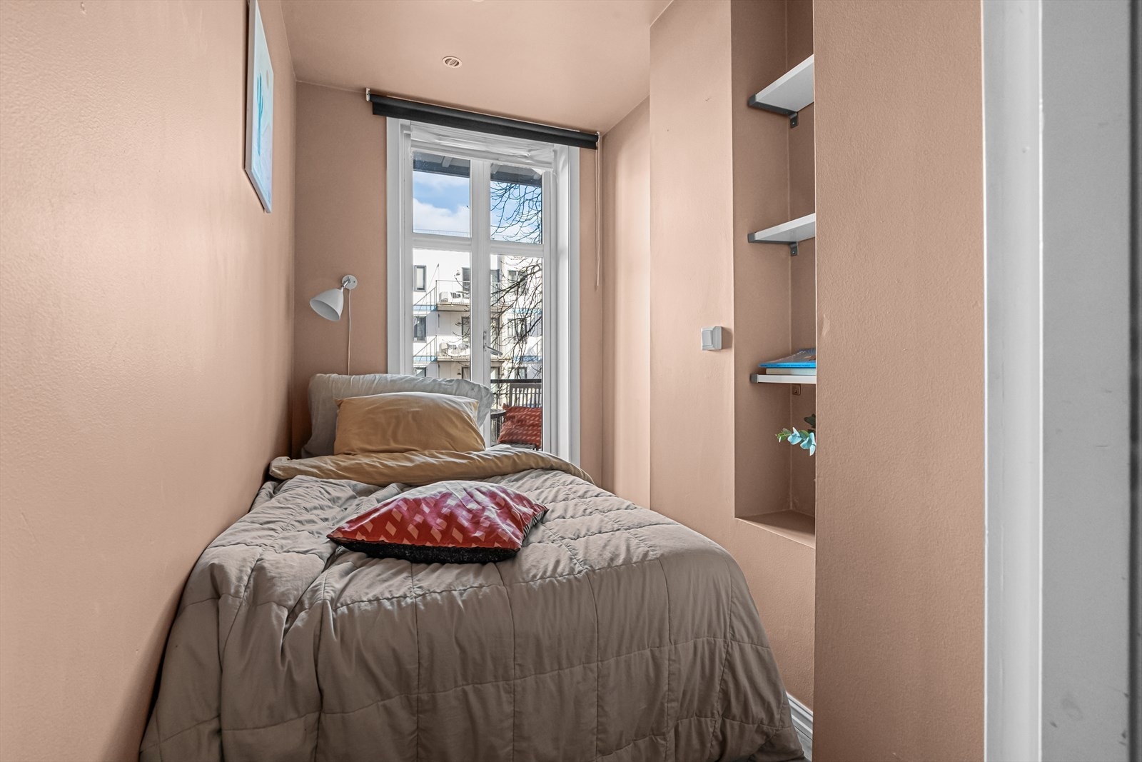 Leiligheten har et lite soverom med plassbygde hyller. Galleribilde