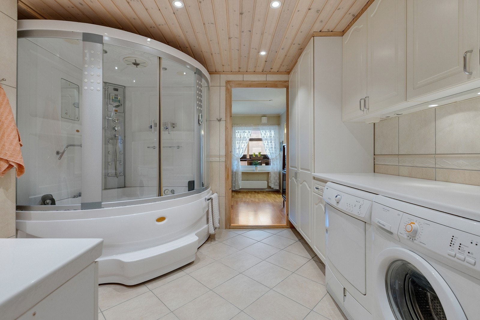 Stort flislagt baderom/vaskerom med god lagringsplass. Galleribilde