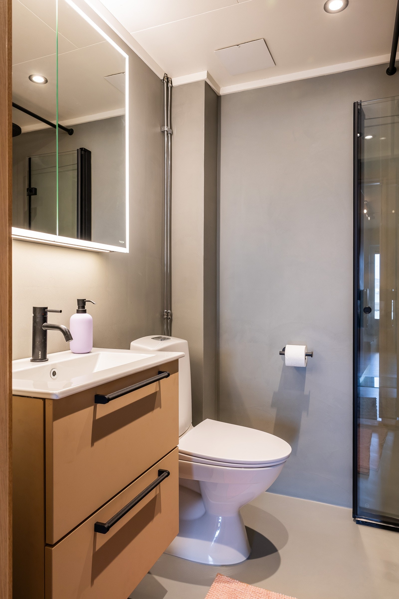 Delikat bad overflateoppusset med mikrosement og ny innredning i 2025. Opplegg for vaskemaskin. Galleribilde