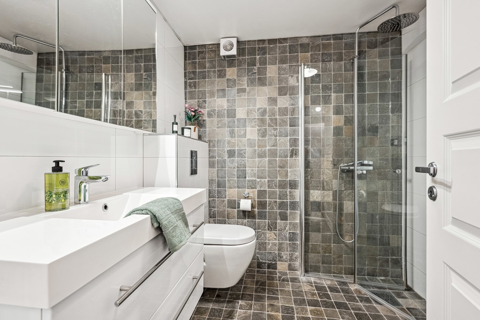 Badet er romslig og pent med fliser på vegger og gulv. Det er varmekabler i gulvet. Galleribilde