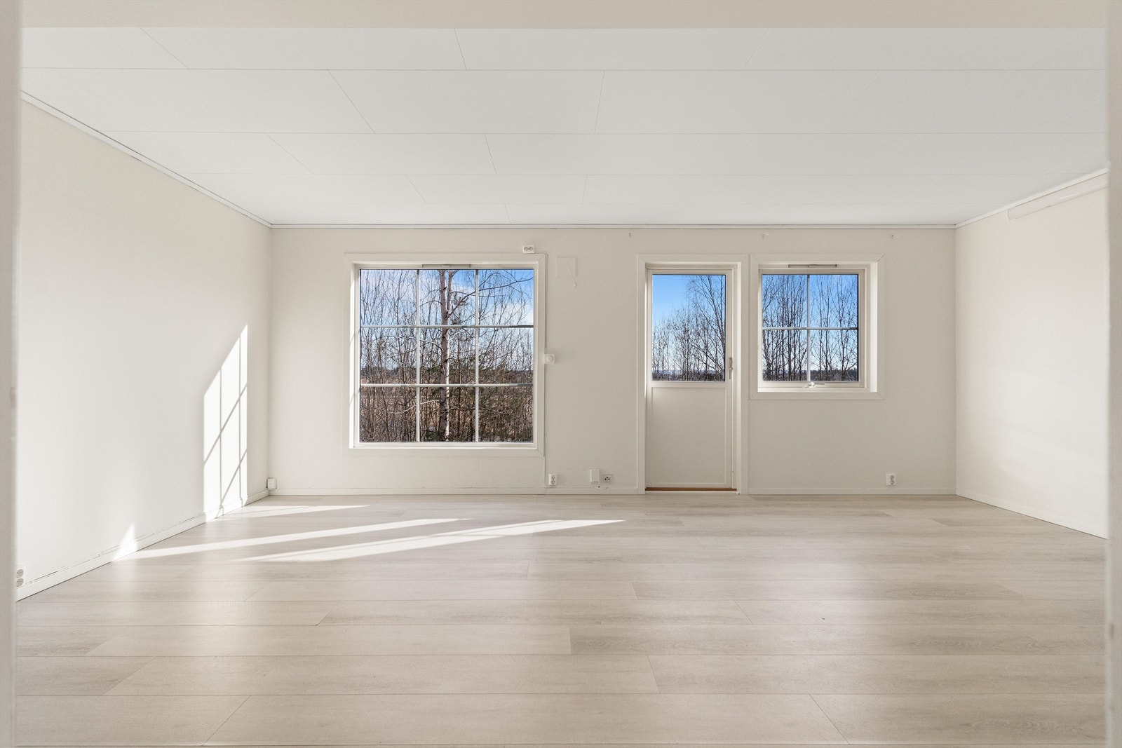 Stuen er lys og luftig, med vinduer som slipper inn rikelig med naturlig sollys og skaper en innbydende atmosfære. Galleribilde