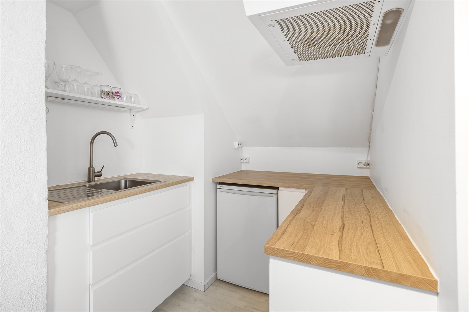 Kjøkkeninnredning med kjøleskap og ventilator. Plass til hybelplatetopp og hybelkomfyr. Galleribilde