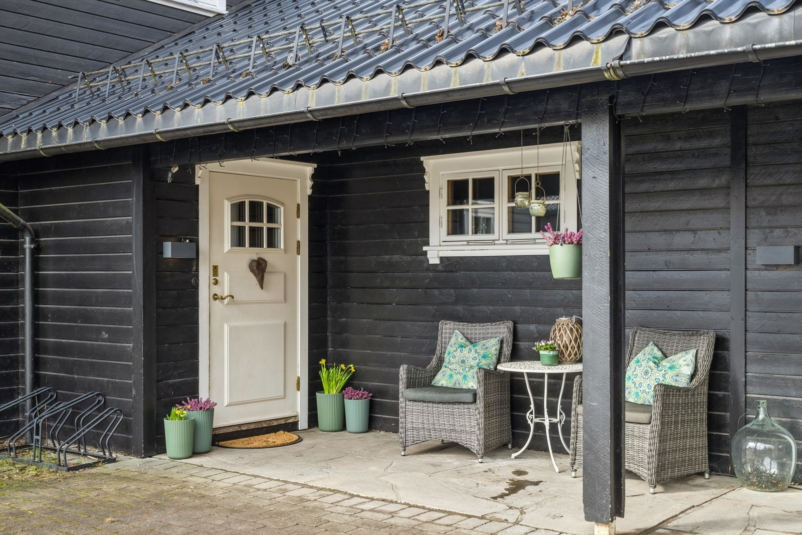 Overbygget fint inngangsparti ved garasjene, svalgang fra dobbel garasje til inngangspartiet. Galleribilde