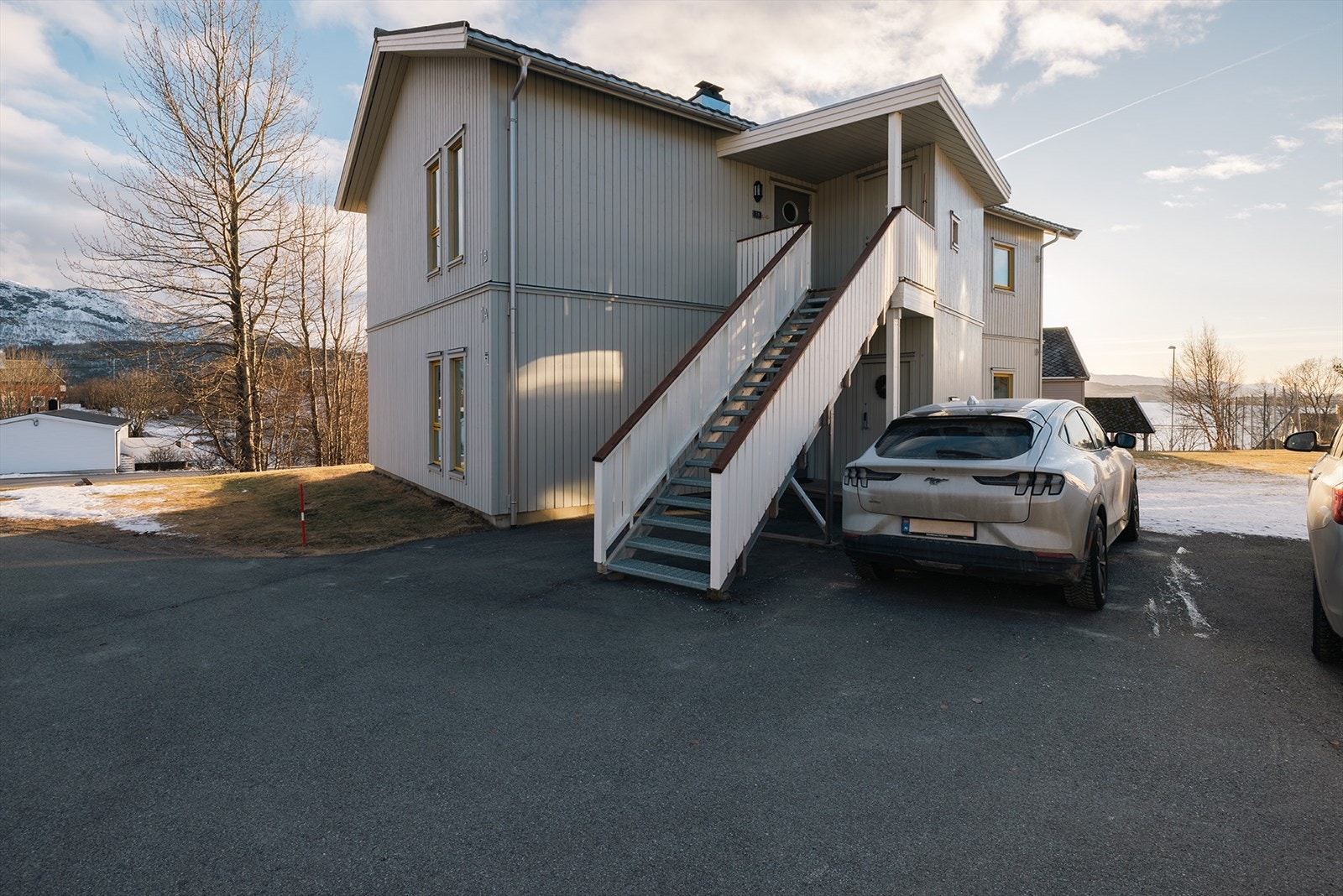 Eget overbygget inngangsparti med morgensol, rett ved garasje og parkering Galleribilde