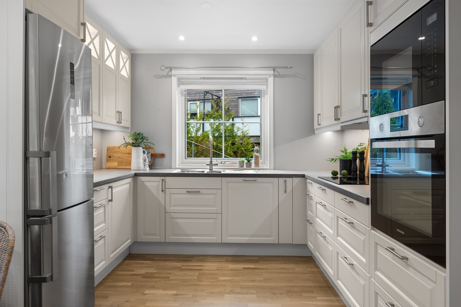 Profilerte kjøkkenfronter i klassisk design fra Ikea. Integrert stekeovn, platetopp, oppvaskmaskin, mikrobølgeovn og kjøleskap med fryser. Galleribilde