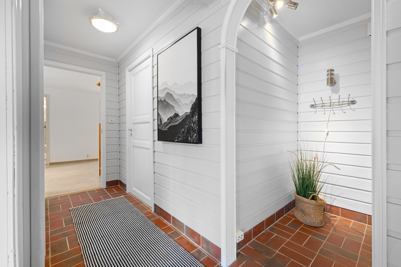 Entré/gang med fliser på gulv. Her er det walk-in til yttertøyet. Galleribilde