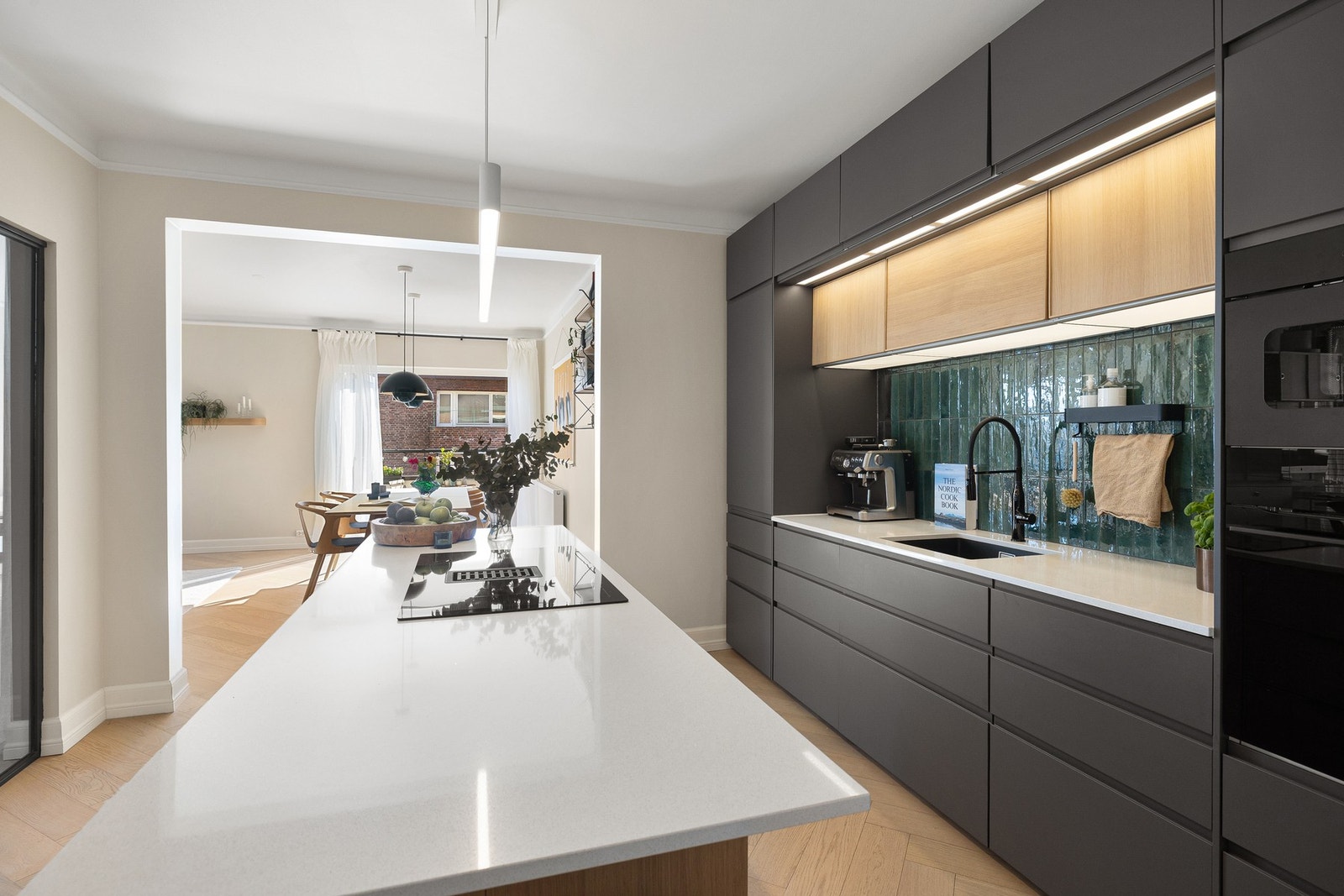 Lekre materialvalg og integrerte hvitevarer skaper et moderne og innbydende uttrykk. Galleribilde