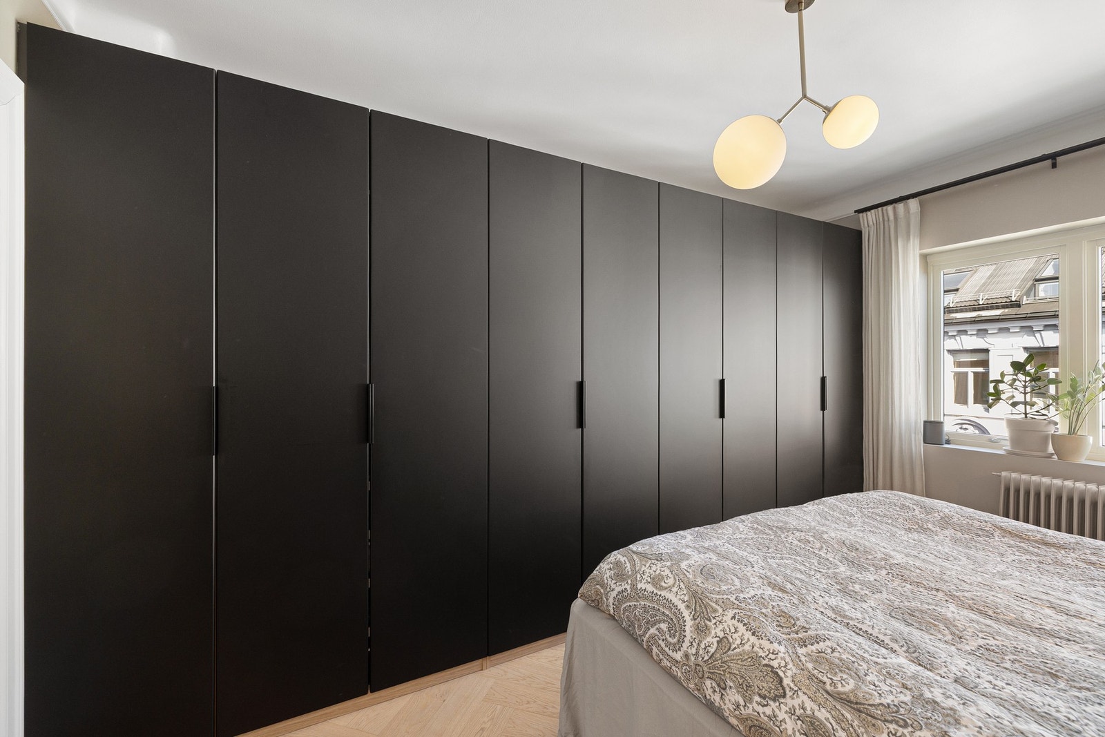 Et garderobeskap som strekker seg fra vegg til vegg gir rikelig med oppbevaringsplass. Galleribilde