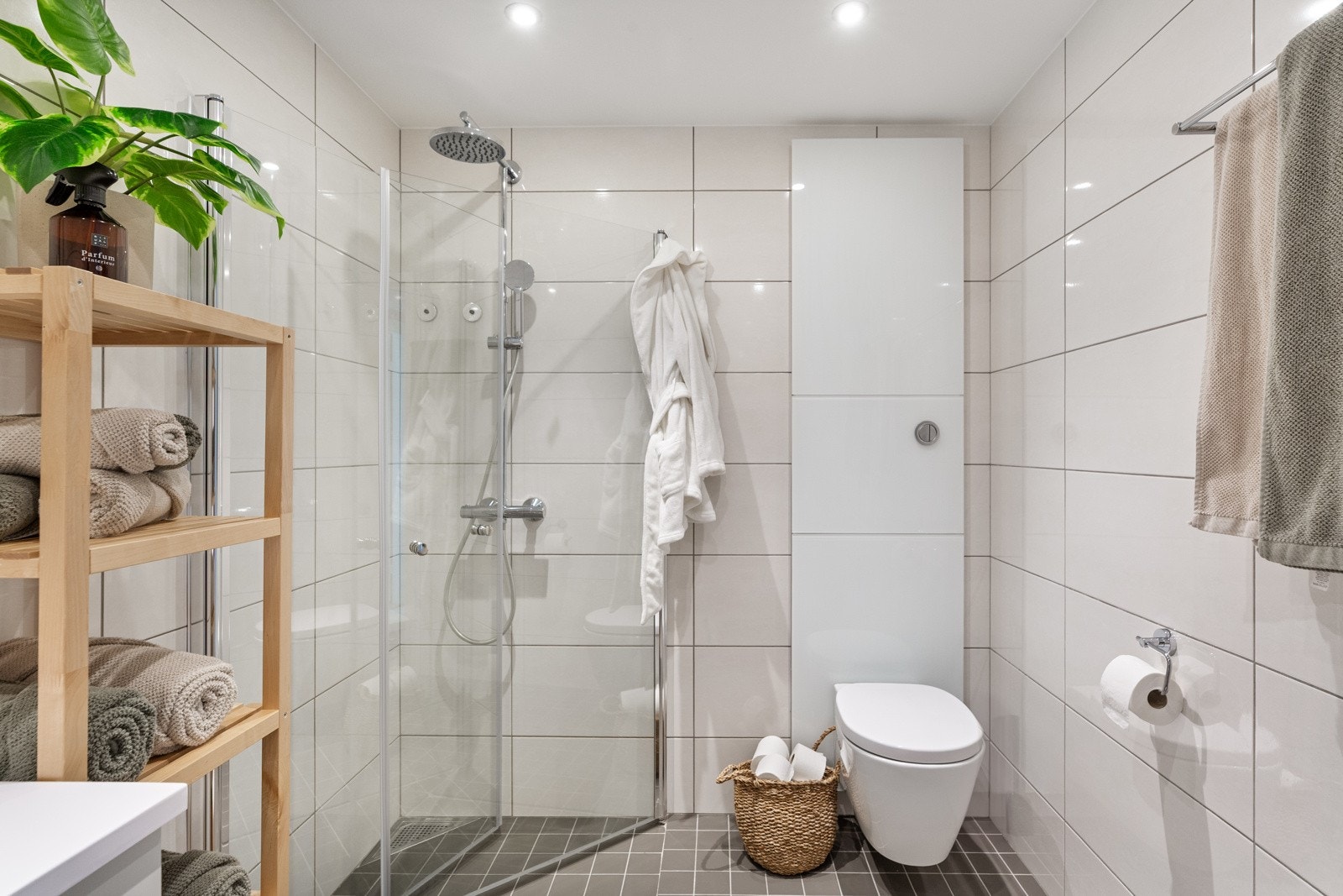 Badet er videre utstyrt med speil med integrert belysning, vegghengt toalett og dusjhjørne med innfellbare dører. Elektriske varmekabler i baderomsgulvet. Galleribilde