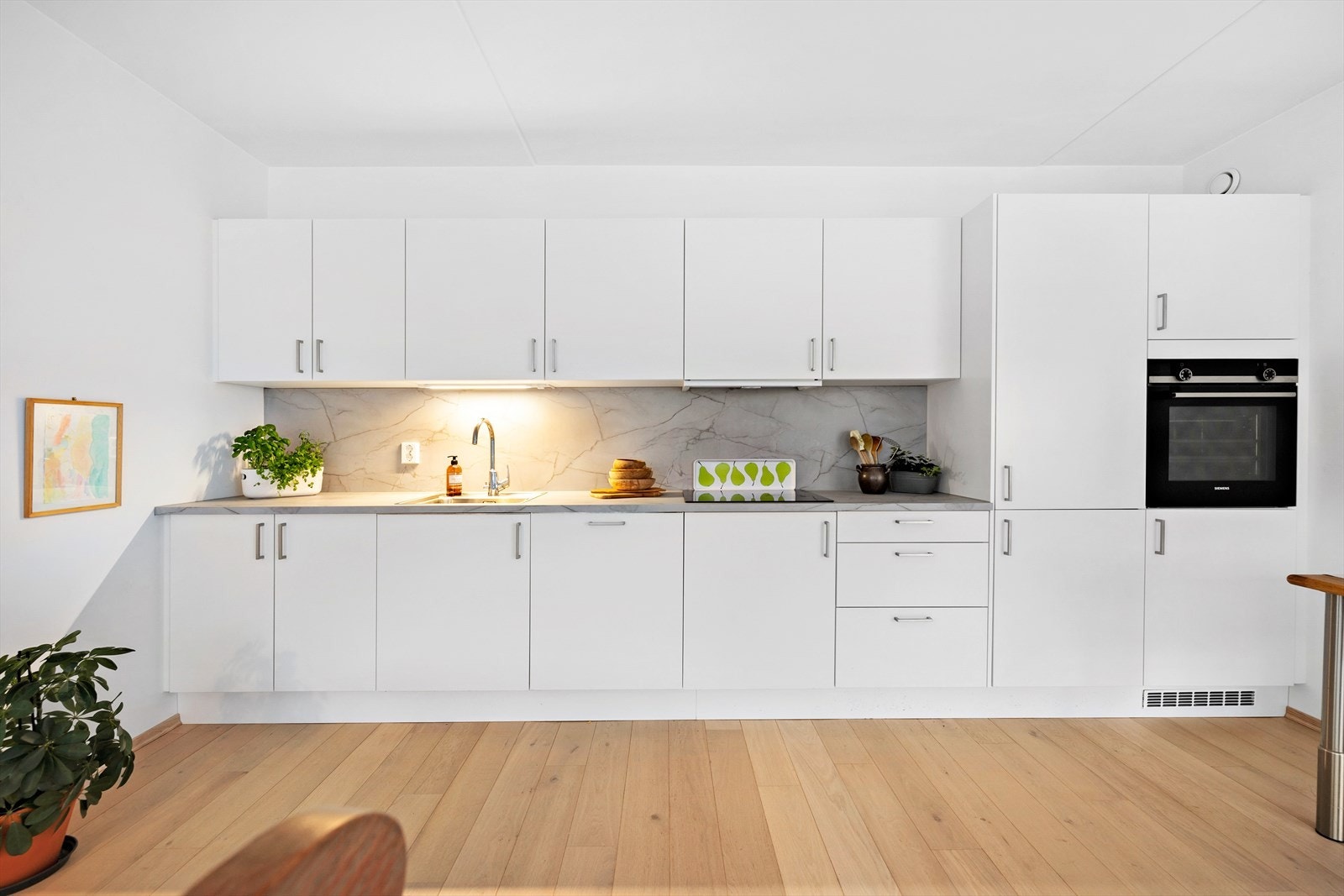 Kjøkkenet har innredning med glatte fronter. Benkeplaten er av laminat. Det er kjøleskap, oppvaskmaskin, komfyr, platetopp og kjøkkenventilator med kullfilter. Galleribilde