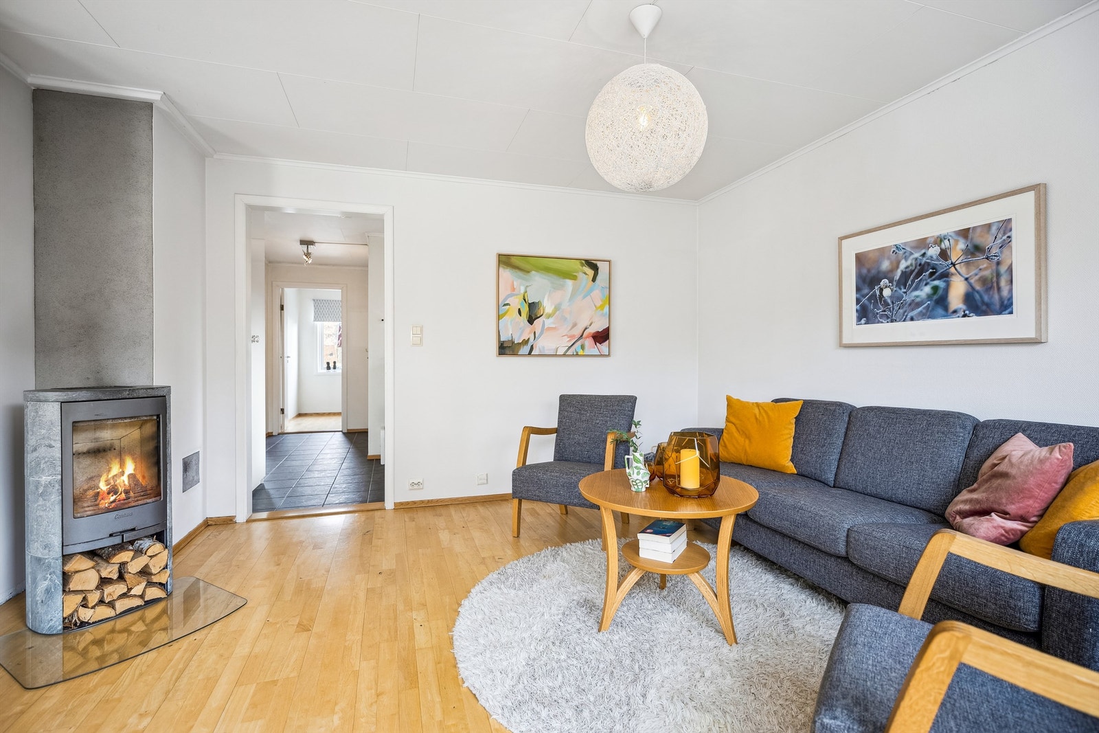 Lys og innbydende stue med åpen løsning til kjøkkenet Galleribilde