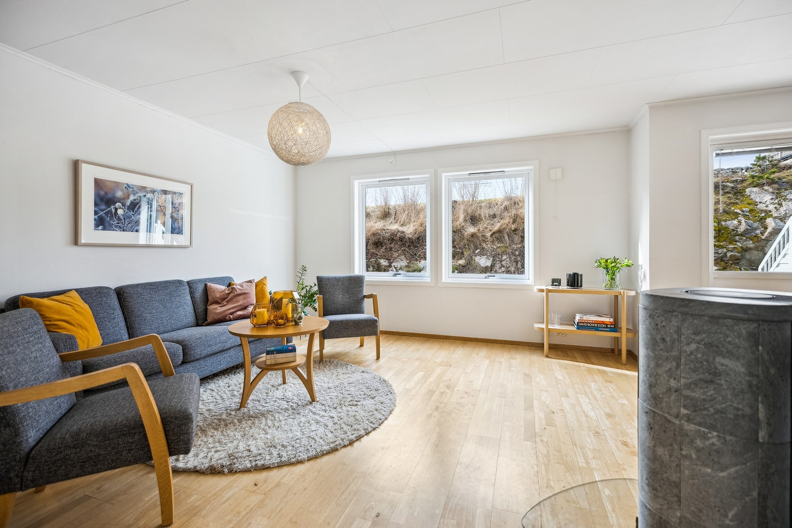 Stuen har gode vindusflater som gir naturlig lysinnslipp inn i boligen, og en peisovn som begge er med på å skape en god atmosfære Galleribilde