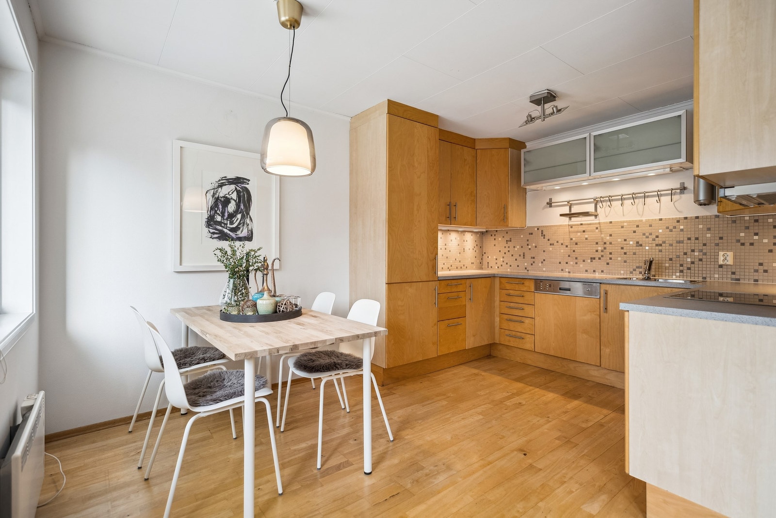 Kjøkkenløsningen er praktisk og funksjonell med godt med skap- og benkeplass. Her er det også god plass til et spisebord. Galleribilde