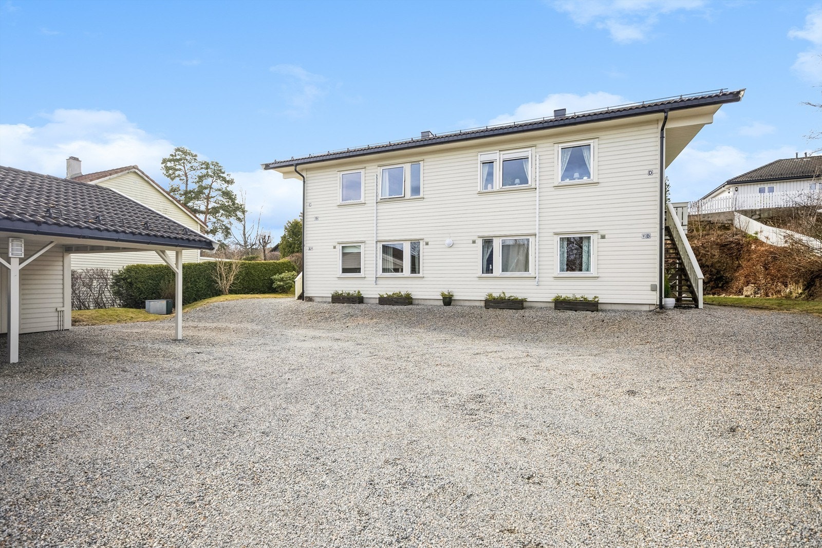 Leiligheten har en hyggelig gårdsplass, og her er det parkering i egen carport, samt biloppstillingsplasser på gårdsplassen Galleribilde