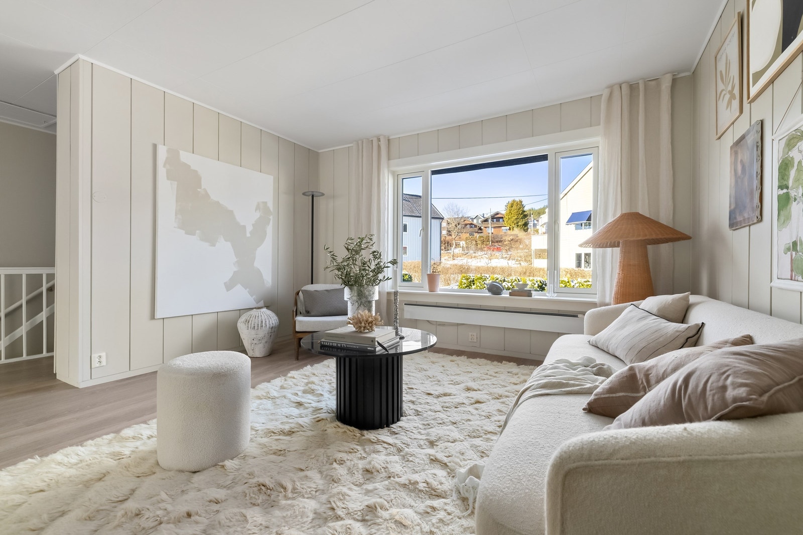 Hyggelig og lun stue med store vindusflater som bidrar til masser av lysinnslipp, som sammen med de lyse overflatene skaper et naturlig lyst rom Galleribilde