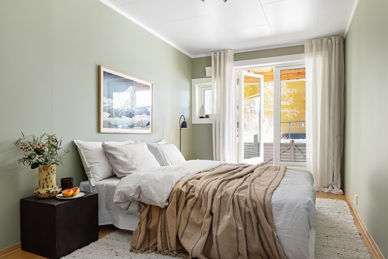 Rommet er malt i en lun farge og gulvflater av parkett. De store vindusflatene byr på rikelig med lys samt utgang til boligens hyggelige terrasse og hage Galleribilde