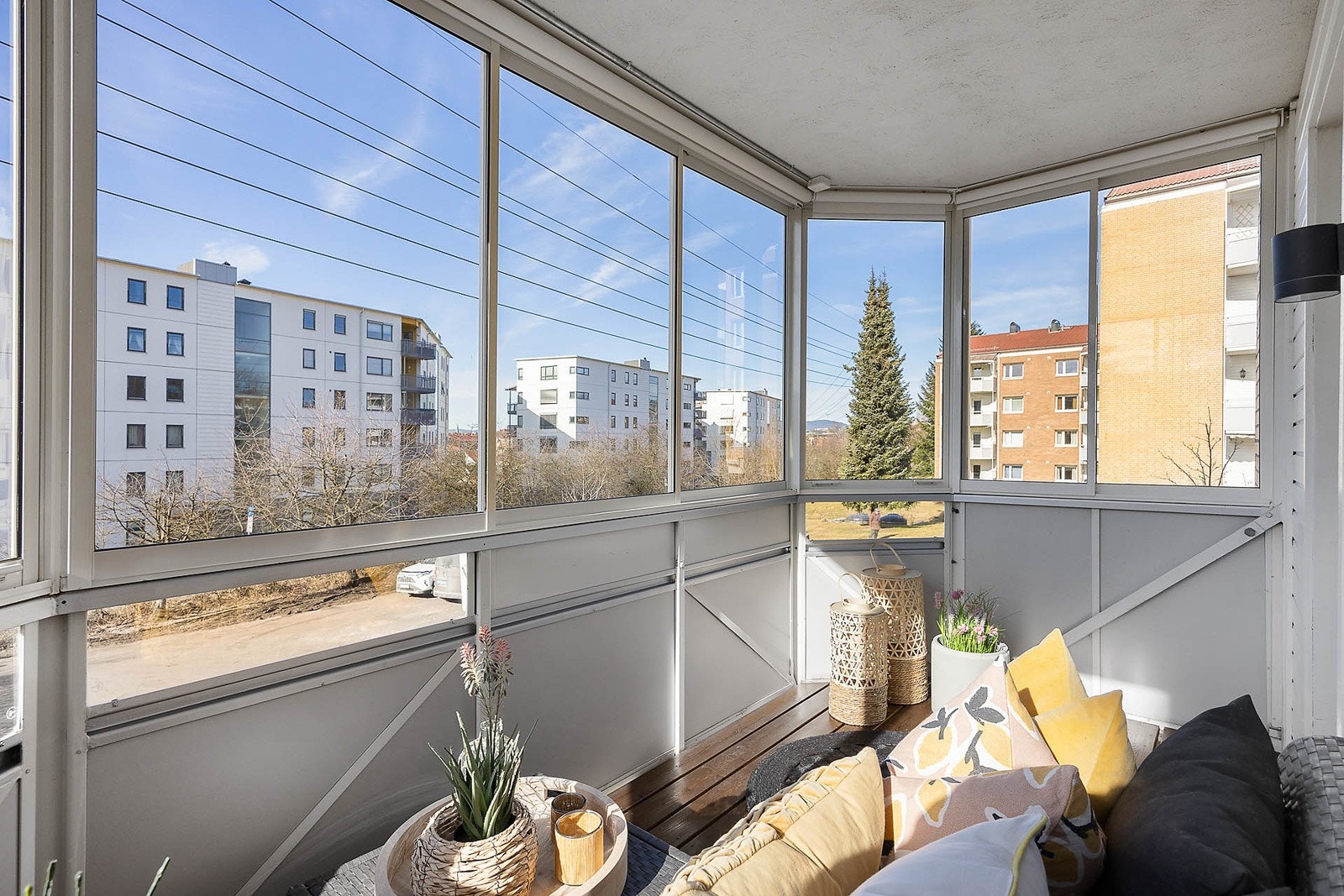 Balkong med terrassebord og elektrisk solskjerming foran 3 glassfelter Galleribilde