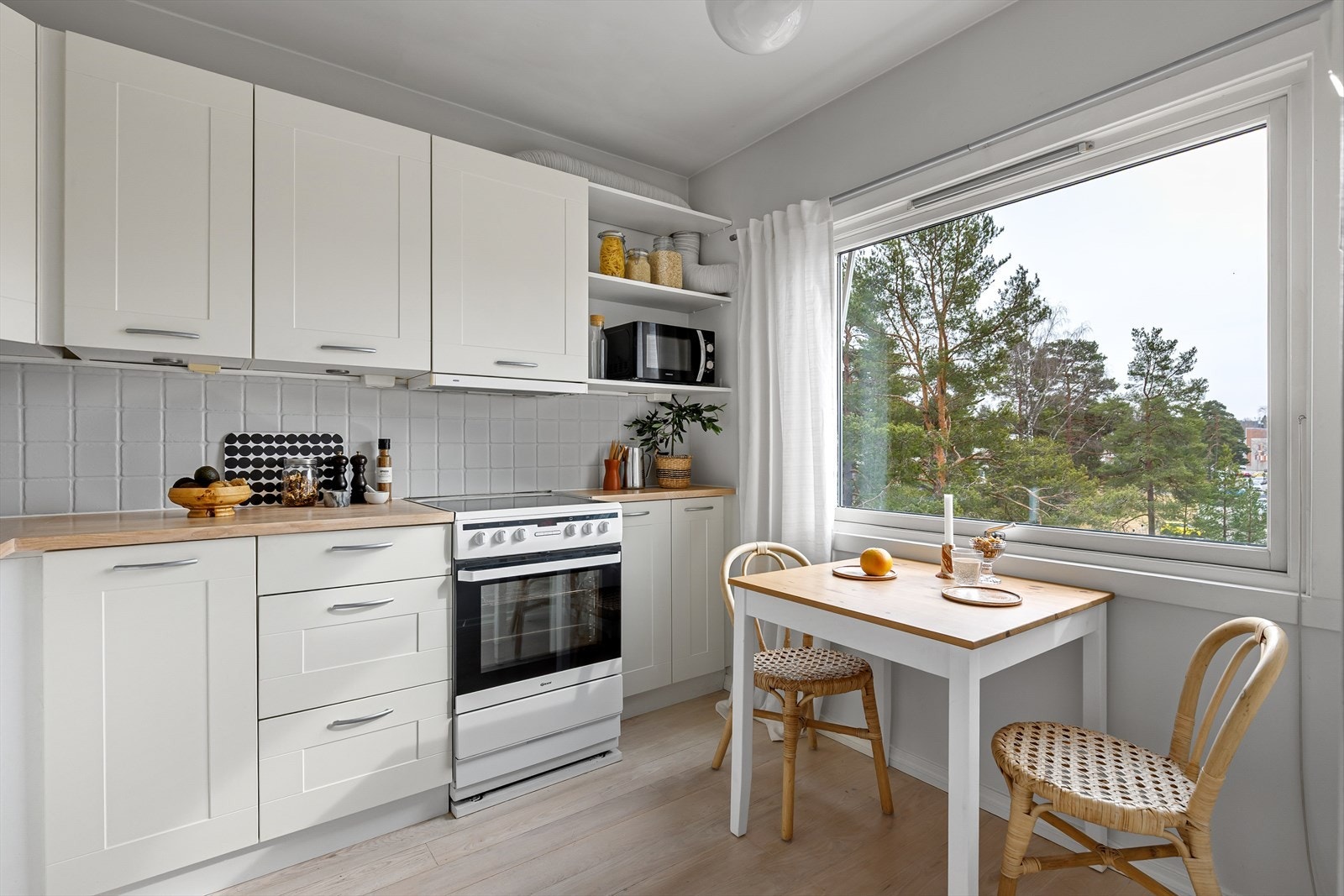 Lyst kjøkken med god skap- og benkeplass i både over og underskap. Galleribilde