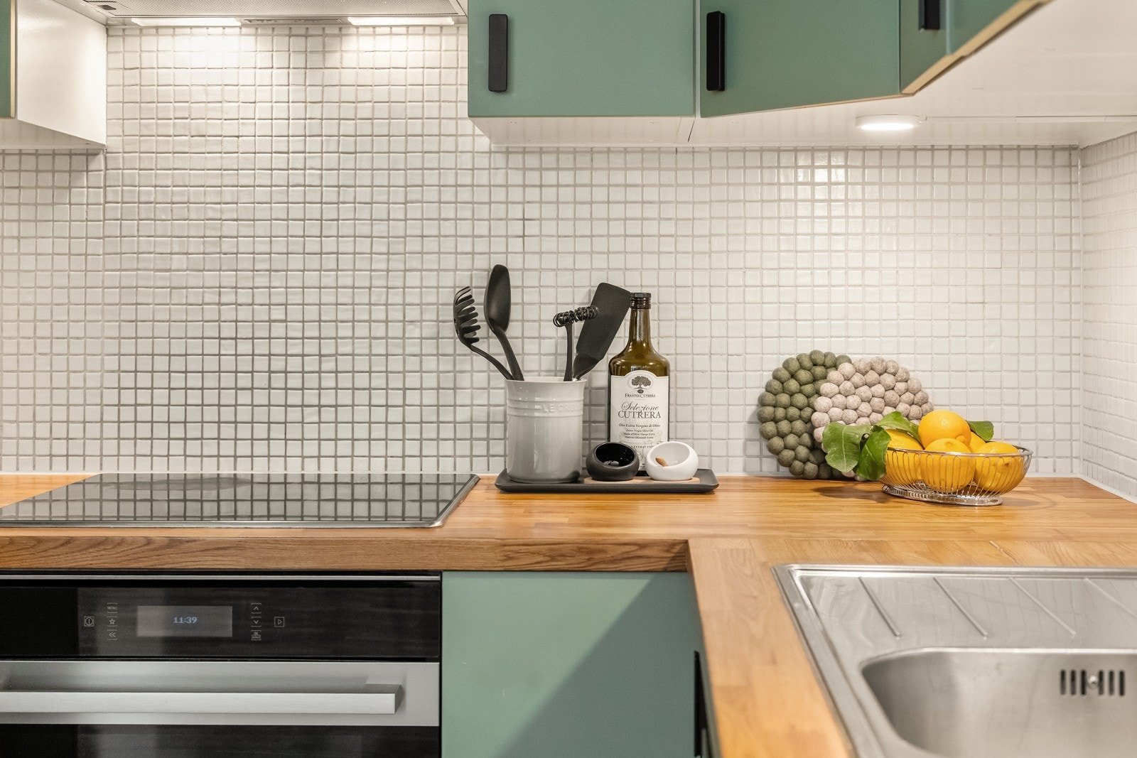 Det er svært god plass på benkeplate av heltre og nedfelt vask i rustfritt stål Galleribilde