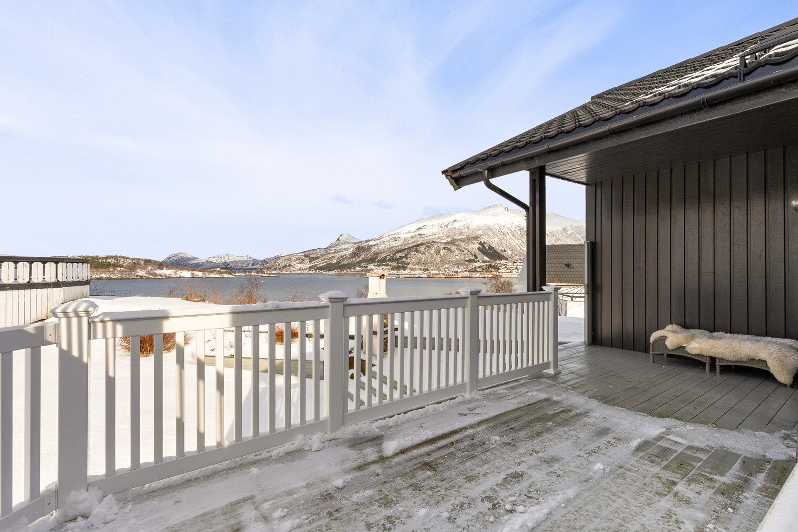 Trapp ned fra verandaen til et svært koselig uteområde i forkant av boligen - omringet av fantastiske omgivelser. Galleribilde