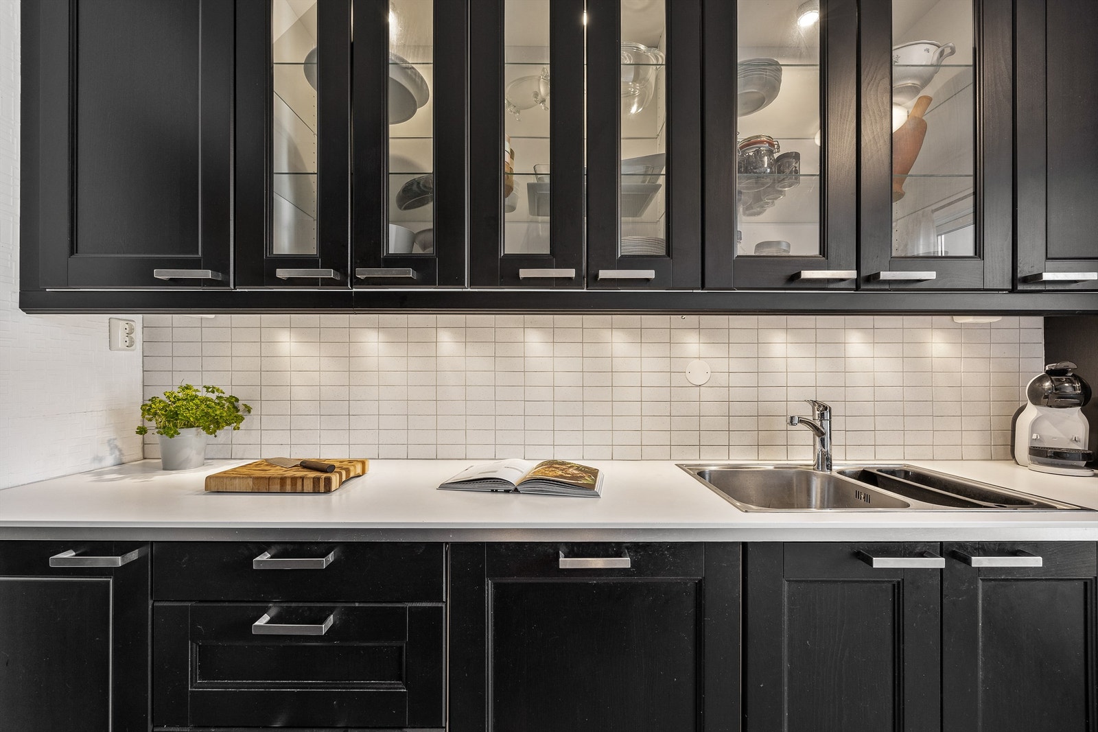 Praktiske løsninger som overskapsbelysning og godt med stikkontakter gjør kjøkkenet til et sosialt og praktisk rom Galleribilde