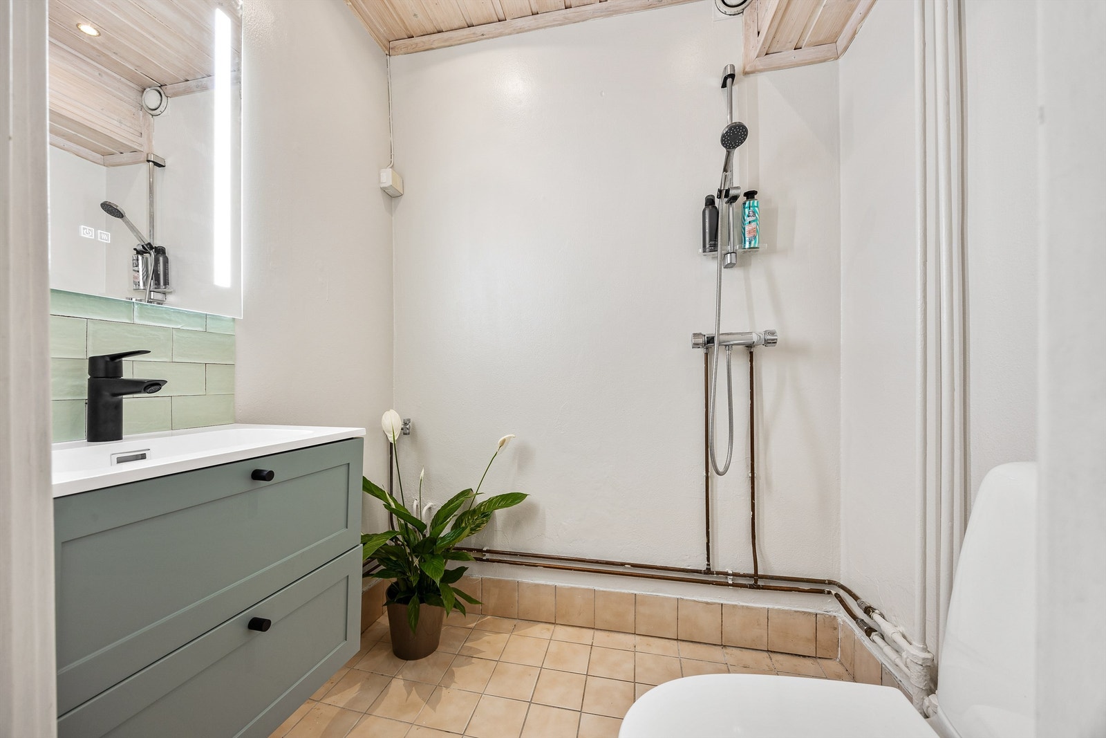 Det har et flislagt gulv med behagelig gulvvarme, vegger i malt mur/betong og himling i trepanel med downlights Galleribilde