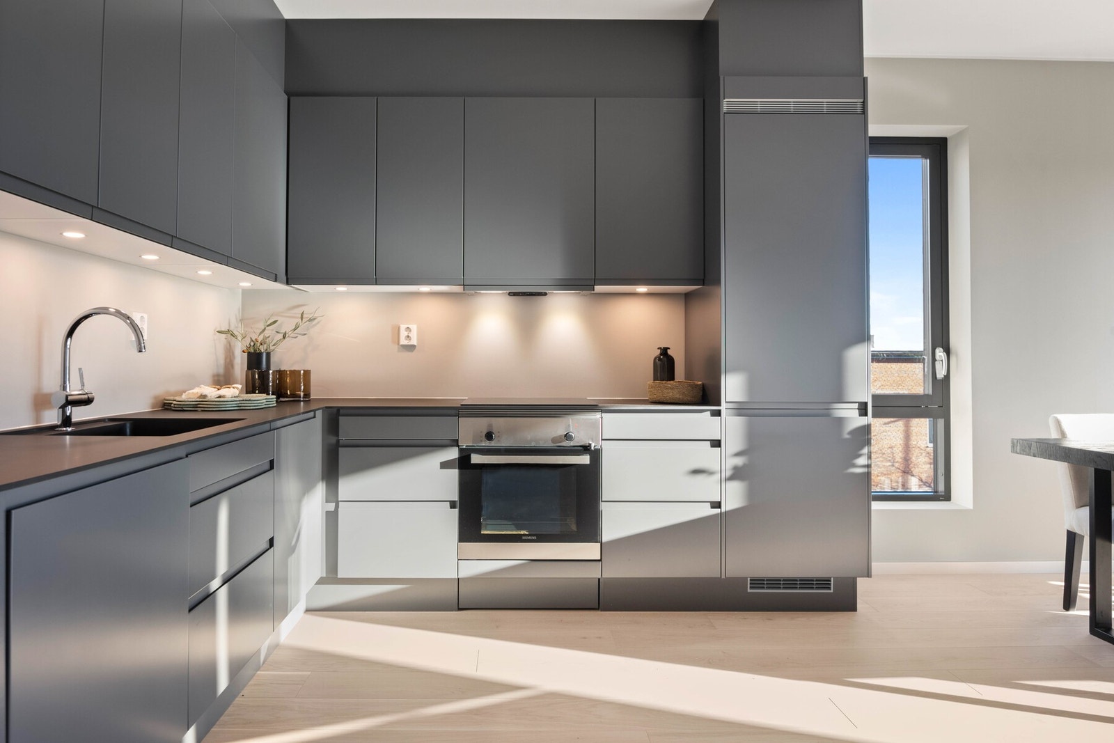 Kjøkkeninnredning er levert av Sigdal i type Horisont med sort laminat benkeplate, med rett forkant. Modellen har slette fronter og innfreste grep som markerer denne oppgraderte modellens linjerene design. Galleribilde