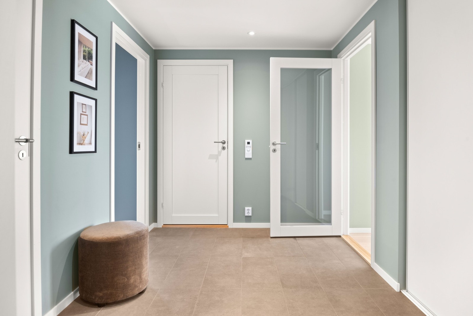 Det leveres vannbåren gulvvarme noe som er gjennomgående for alle oppholdsrom, noe som gir en jevn og komfortabel temperatur året rundt. Taket er lyssatt med downlights, og en elegant glassdør mellom entreen og oppholdsrommet sørger for naturlig lys i rom Galleribilde