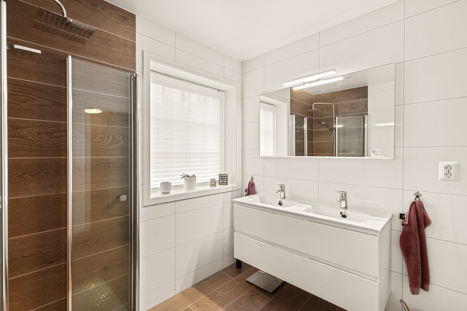 Badet er innredet med vegghengt toalett, dusjhjørne m/glassdører og dobbel servant med innredning/speil/belysning Galleribilde