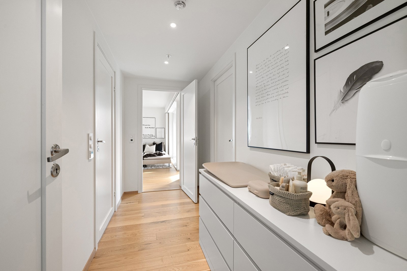 Gangen er bred, og det er dermed god plass til kommoder langs ene veggen. Hovedsoverommet ligger innerst i leiligheten og har 1-stavs parkett på gulv og malte slette flater på vegger Galleribilde