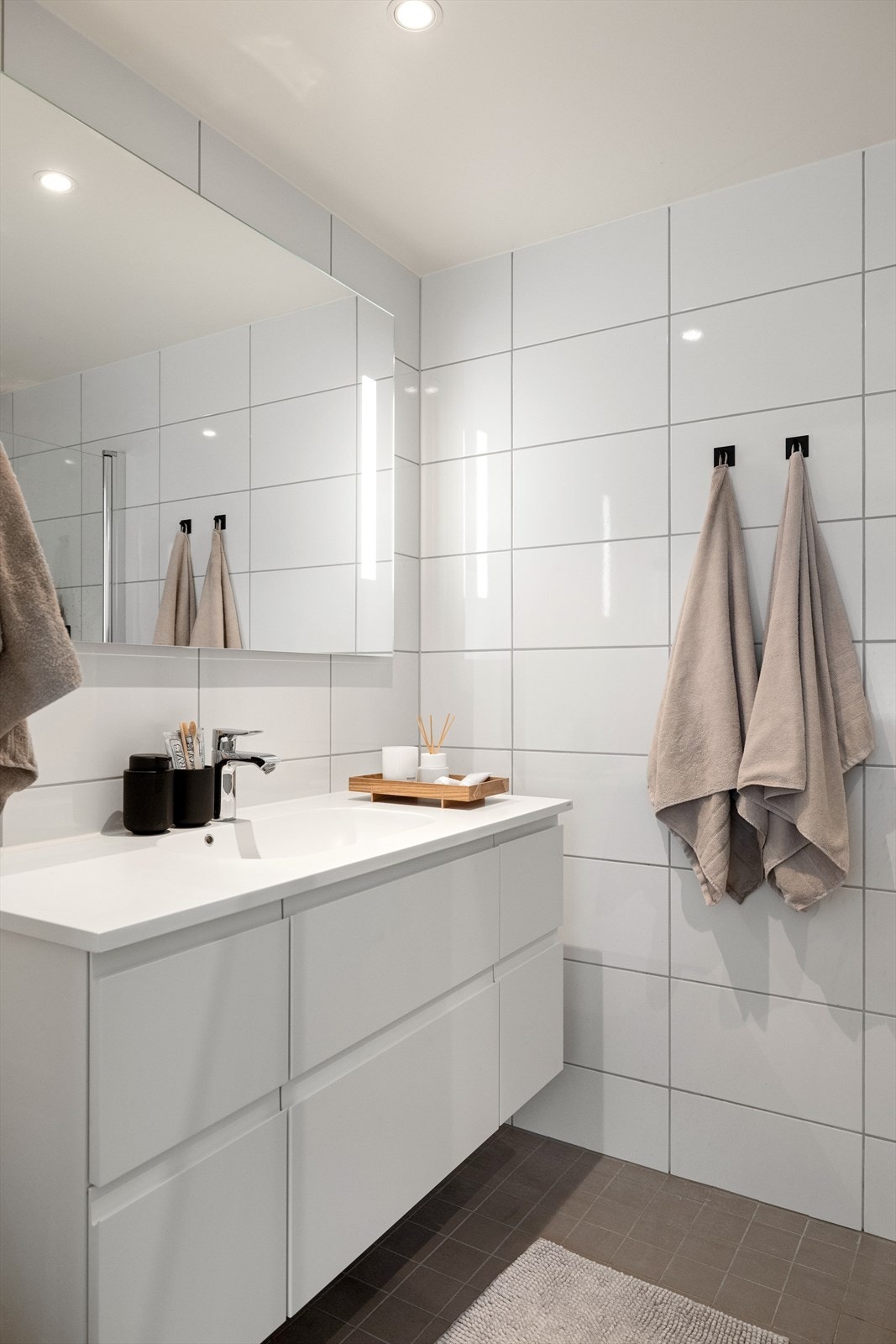 Badet har adkomst fra hovedsoverommet og har en lys og moderne baderomsinnredning med nedfelt servant og skuffer. Over servanten er det et stort speil med integrert lys Galleribilde