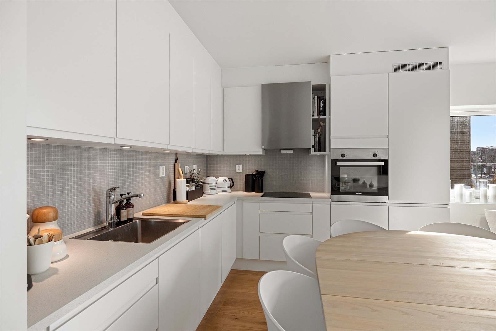 Moderne og nøytralt kjøkken fra HTH med integrerte hvitevarer fra Siemens og Bosch. Innredningen er fra 2021 og har minimalt med slitasje Galleribilde