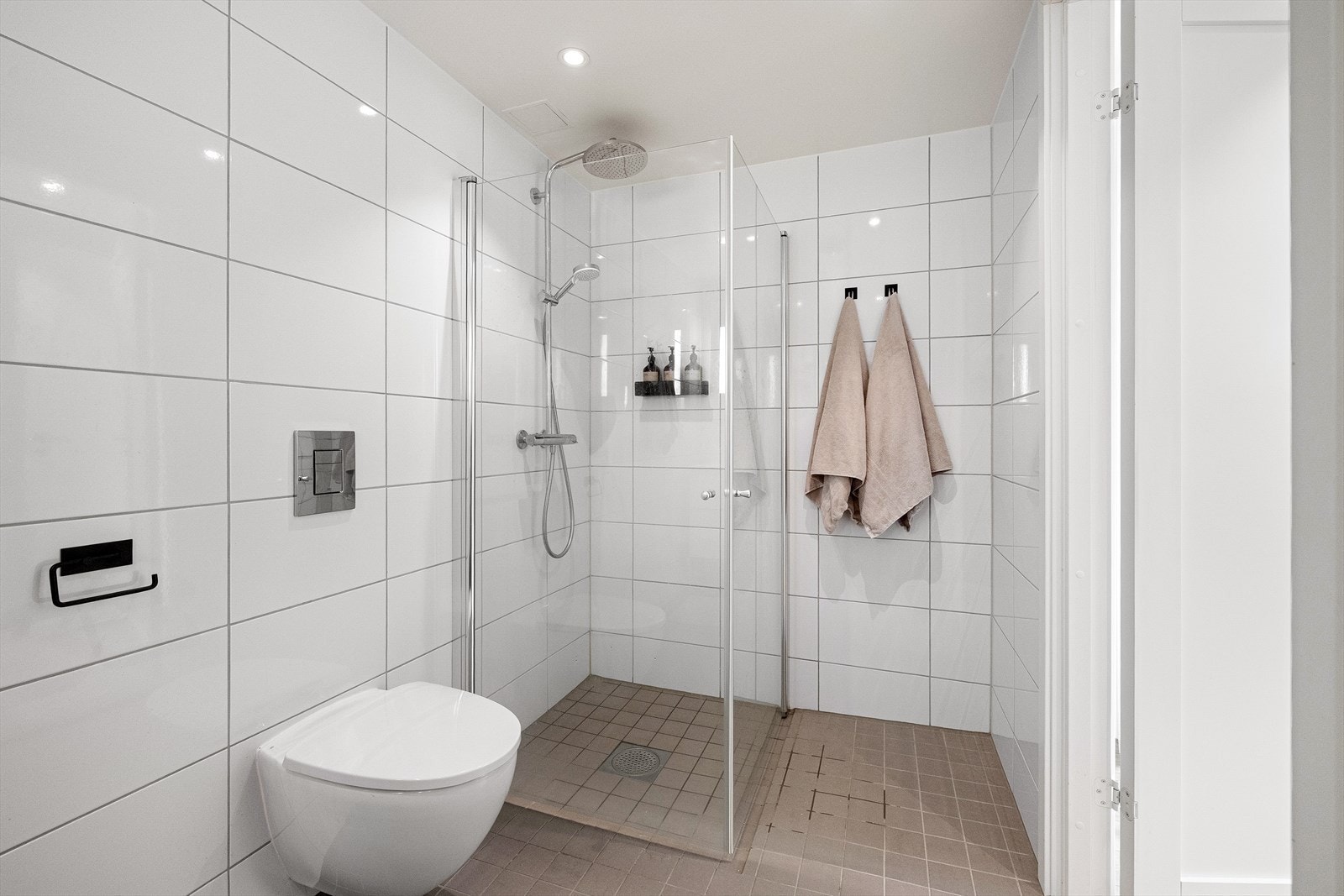 Rommet har en innredning med nedfelt servant med 2 skuffer og speil over vasken. Det er veggmontert toalett og innfellbare dusjvegger i herdet glass samt regnfallsdusj og håndholdt spyler. På rommet er det opplegg for vaskemaskin og tørketrommel Galleribilde