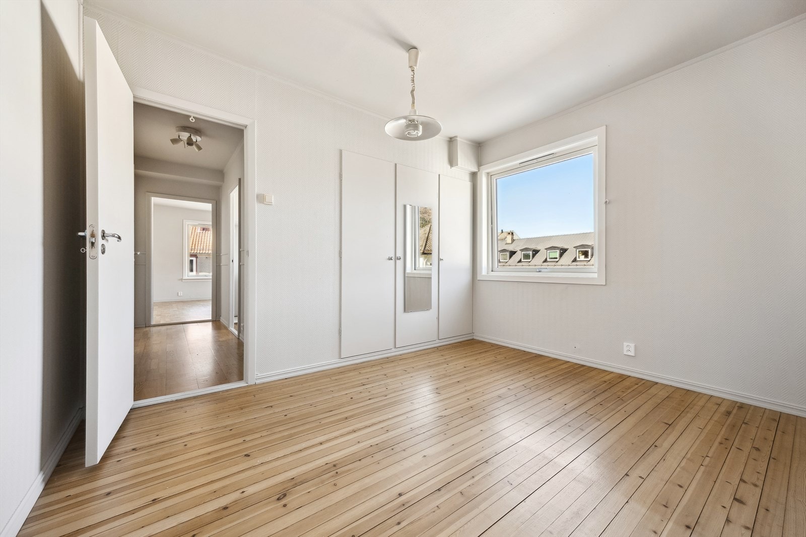 Romslig soverom på ca. 12,8 m² med god plass til dobbeltseng og nattbord. Det innebygde skapet gir praktisk oppbevaring av klær Galleribilde