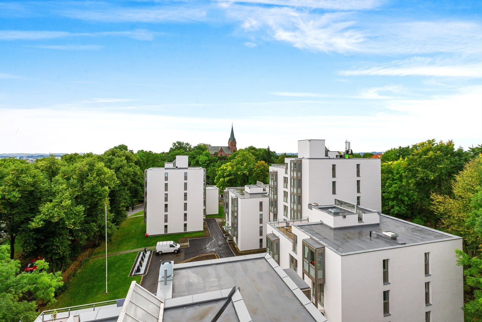 Borettslaget ligger omkranset av trær og annen beplantning Galleribilde